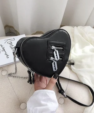 Herzförmige Tasche mit Reißverschlussdetails und schwarzem Lederriemen