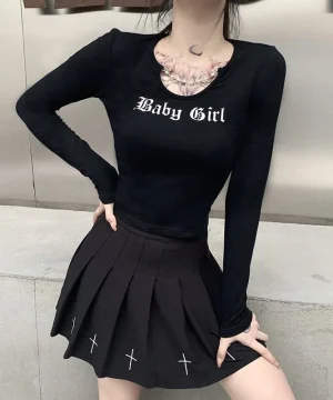 Zweiteiliges schwarzes Outfit: Top mit "Baby Girl"-Schriftzug und Faltenrock.