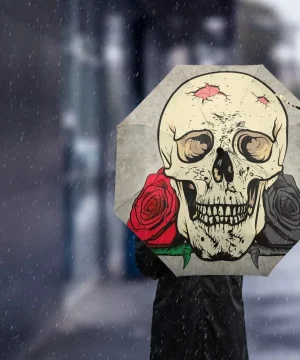 „Regenschirm mit Totenkopf und Rosen im Regen“